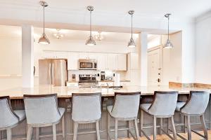 a kitchen with a large island with chairs in it at Guesthouse Charleston SOUTH 105 A in Charleston