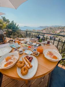 a wooden table with plates of breakfast food on it at Hill House Adult Only in Kaş