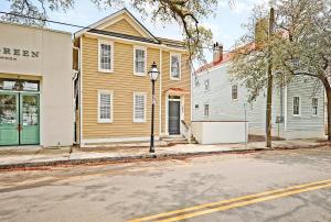 een geel huis en een wit gebouw op een straat bij Guesthouse Charleston SOUTH 105 A in Charleston