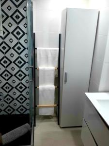 ein Bad mit einem Kühlschrank und Handtüchern in der Unterkunft Aldeia Studio Albufeira in Albufeira