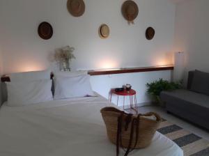 ein Schlafzimmer mit einem weißen Bett und einem Sofa in der Unterkunft Aldeia Studio Albufeira in Albufeira