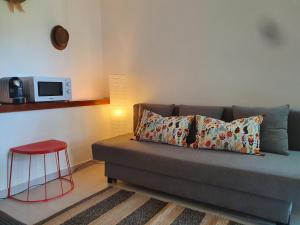 ein Wohnzimmer mit einem Sofa und einem roten Stuhl in der Unterkunft Aldeia Studio Albufeira in Albufeira