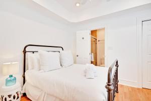 Dormitorio blanco con cama con almohadas blancas en Guesthouse Charleston SOUTH 105 A en Charleston