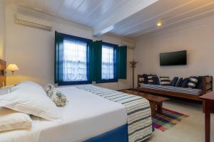 
a hotel room with a bed and a television at Pousada Porto Imperial in Paraty
