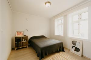 a white bedroom with a bed and a window at Bergen Beds - Serviced apartments in the city center in Bergen