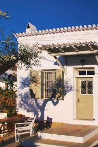 a white house with a yellow door and a table at Aria House in Spetses