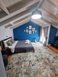 a blue bedroom with a bed and a large rug at Deisisroom nafplio poseidon in Nafplio