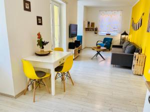 a living room with a table and yellow chairs at Apartmán Kežmarok in Kežmarok