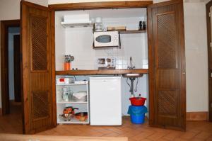 una pequeña cocina con nevera y microondas en Apartamentos Turísticos - Hostal Los Alisos, en Aliseda