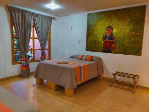 a bedroom with a bed and a painting on the wall at María Arte Hotel in San Cristóbal de Las Casas