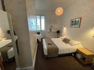 een kleine kamer met 2 bedden en een spiegel bij Ōtoromiro Hotel in Governors Bay