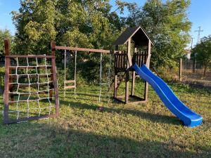 un parque infantil con tobogán y columpio en Panoráma Vendégház, en Golop