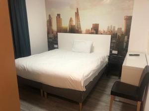 a bedroom with a white bed with a city skyline at Barking Park Hotel in Barking