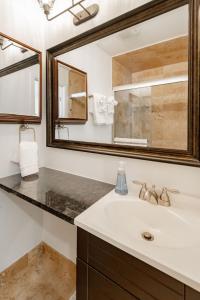 La salle de bains est pourvue d'un lavabo et d'un miroir. dans l'établissement Guesthouse Charleston SOUTH 105 B, à Charleston