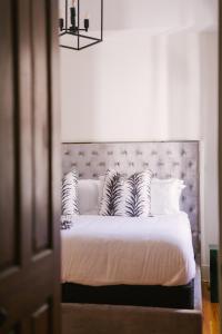a bedroom with a bed with white sheets and pillows at Guesthouse Charleston SOUTH 82 A and B in Charleston