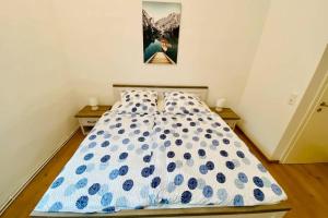 a bedroom with a bed with a blue and white comforter at FeWo Seenest in Goslar