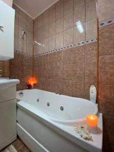 La salle de bains est pourvue d'une baignoire avec une bougie et une bougie. dans l'établissement Daniela's Apartaments, à Sighişoara