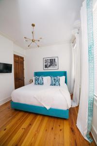 a bedroom with a blue bed and a ceiling fan at Guesthouse Charleston SOUTH 82 B in Charleston