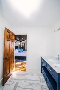 a bathroom with a sink and a door leading to a bedroom at Guesthouse Charleston SOUTH 82 B in Charleston
