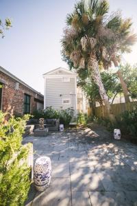 un patio con una palmera y una casa en Guesthouse Charleston SOUTH 82 B, en Charleston