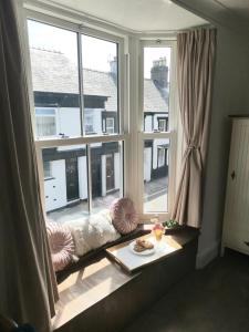 um assento de janela num quarto com duas janelas grandes em The Bridge Cottage em Llanrwst