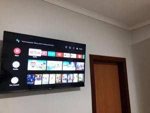 a flat screen tv on a wall next to a door at Pousada Papaya - Bonito in Bonito