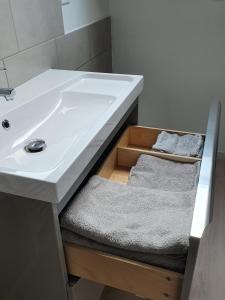 a bathroom with a sink and a drawer with towels at Avocette in Yvrench