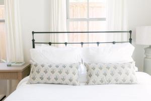 Un dormitorio con una cama con sábanas y almohadas blancas. en Guesthouse Charleston WEST 242 C, en Charleston