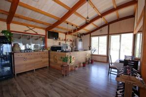 a large room with a kitchen with wooden floors at Bujtina e Muriqit in Shkodër