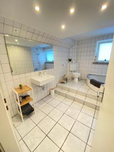 a bathroom with a tub and a toilet and a sink at Appartement Apelern (A2) - 2 Zimmer, Badewanne, Terrasse, Netflix in Apelern