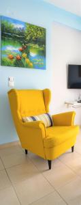 ein gelbes Sofa im Wohnzimmer mit einem Gemälde in der Unterkunft Amazing place in Pedini in Ioannina