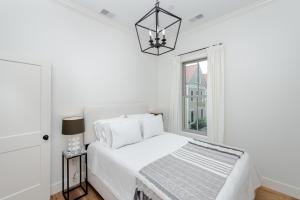Un dormitorio blanco con una cama y una ventana. en Guesthouse Charleston WEST 242 B, en Charleston