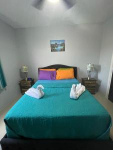 a bedroom with a green bed with towels on it at Jamrock Suites in Kingston