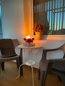 - une table avec deux verres de vin et deux chaises dans l'établissement Daniela's Apartaments, à Sighişoara