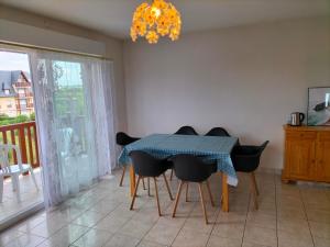 une salle à manger avec une table, des chaises et un lustre dans l'établissement Le Trianon, Magnifique appartement proche plage et Deauville, à Blonville-sur-Mer