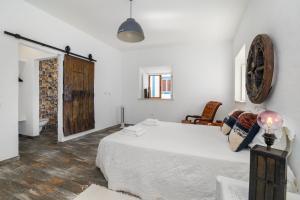una camera con un grande letto bianco di Casa Celeiro a Estômbar