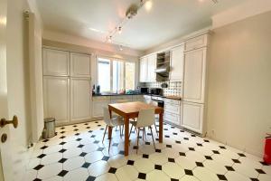 a kitchen with a table and chairs on a checkered floor at Highstatic - Large and Bright 2BR in the nightlife District in Luxembourg