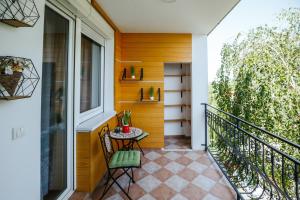 a balcony with a table and chairs on a house at Green Duplex in Novi Sad