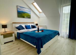 a bedroom with a bed with a blue blanket at Apartament Jak Marzenie in Ustrzyki Dolne