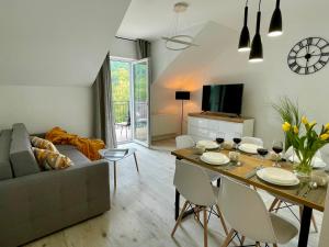 salon z kanapą i stołem z krzesłami w obiekcie Apartament Jak Marzenie w mieście Ustrzyki Dolne