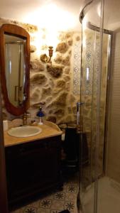 a bathroom with a sink and a shower with a mirror at Casa da Ti Maria Pereira in Monsanto