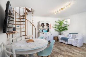 a living room with a table and chairs and a bed at Casa Cachalote in Ferragudo