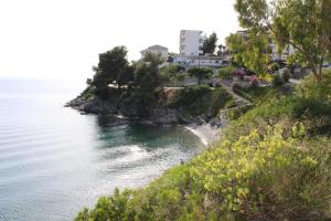 ネオス・マルマラスにあるAkrotiri Hotelの家屋と水辺のあるビーチの景色を望めます。