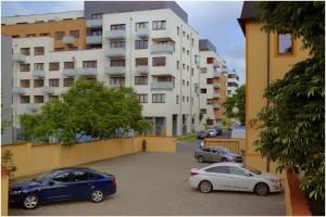 dos autos estacionados en un estacionamiento frente a un edificio en Attic Hotel, en Praga