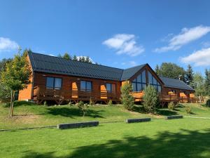 uma grande cabana de madeira com um telhado preto em Wellness penzion Marta em Kuklík