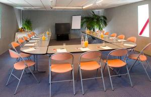 ein großer Konferenzraum mit einem langen Tisch und Stühlen in der Unterkunft Hôtel Le Montaigu in Luz-Saint-Sauveur