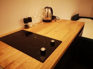 - un ordinateur portable sur un bureau en bois avec des verres et un mixeur dans l'établissement Apartamenty LENA 1, à Racibórz