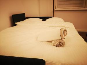 a white bed with a rolled up towel on it at Apartamenty LENA 1 in Racibórz