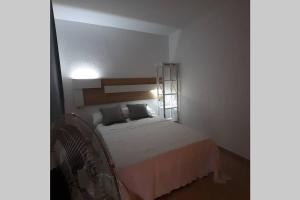 a bedroom with a white bed with a mirror at Agradable casa para disfrutar con los tuyos in Gran Alacant