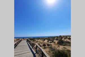 a boardwalk over the beach in the desert at Agradable casa para disfrutar con los tuyos in Gran Alacant